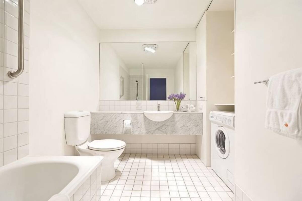 Ein Badezimmer mit Toilette, Waschbecken, Badewanne und Waschmaschine.