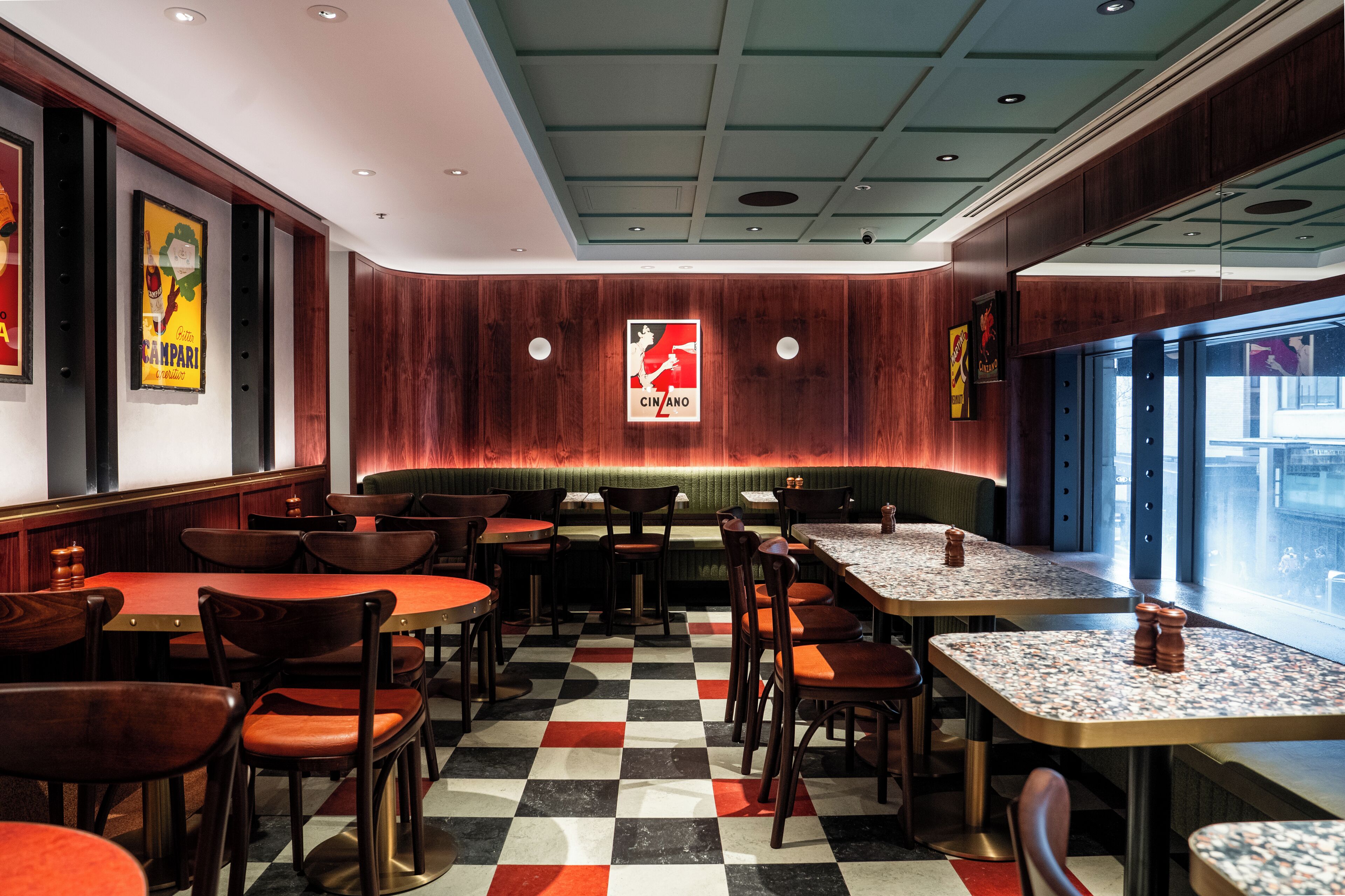 A restaurant with checkered flooring, wooden walls, and a variety of seating options including booths and tables.
