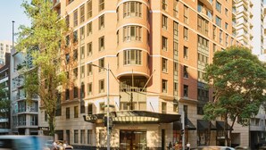 Un hôtel à plusieurs étages, doté d’une façade incurvée, de grandes fenêtres et d’une entrée imposante.