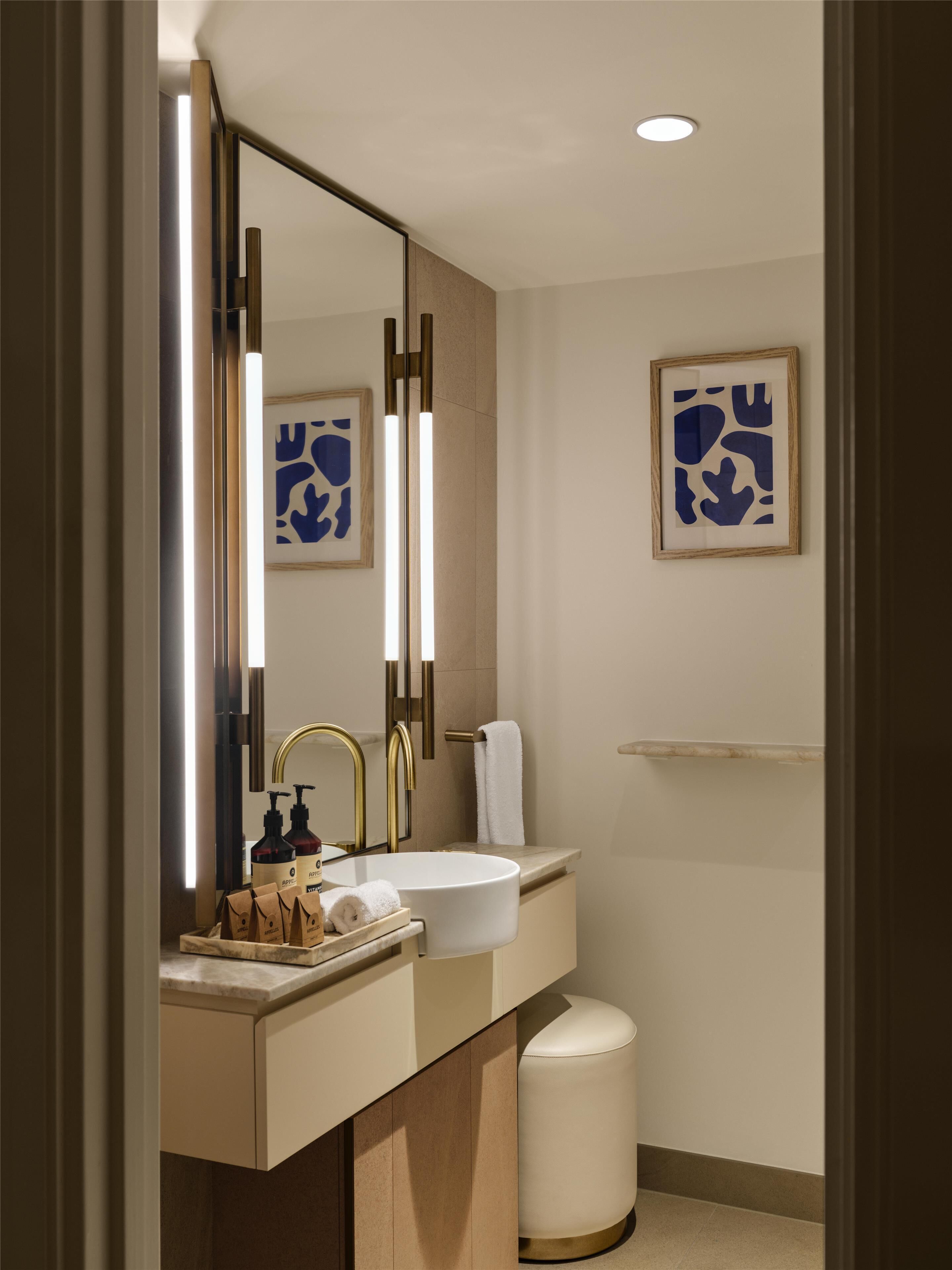 Ein modernes Badezimmer mit großem Spiegel, Waschbecken und Toilette.