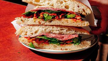 A sandwich on a plate with a paper wrapper.
