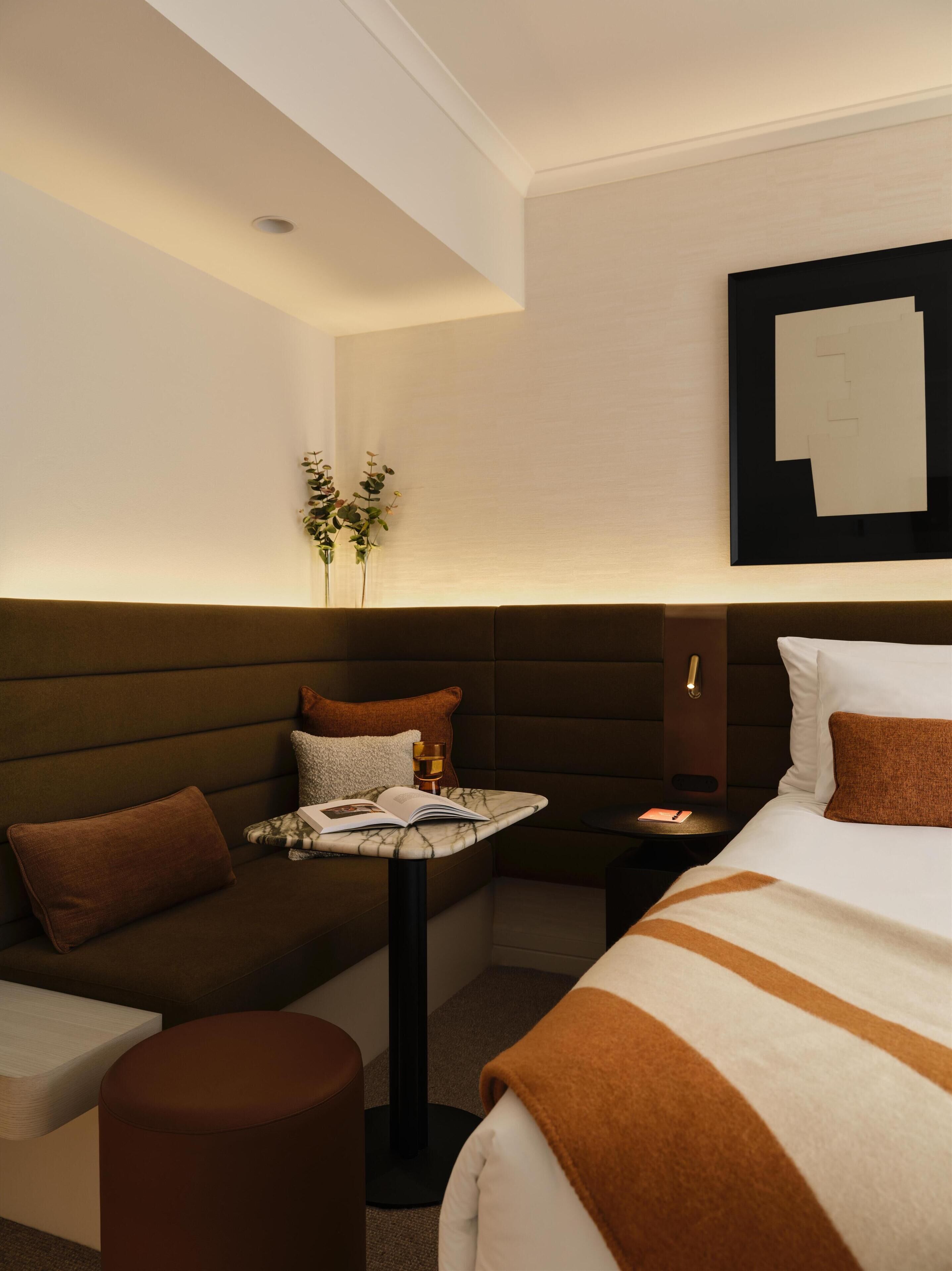 Une chambre d’hôtel avec un lit, un canapé, une petite table et une table de chevet.