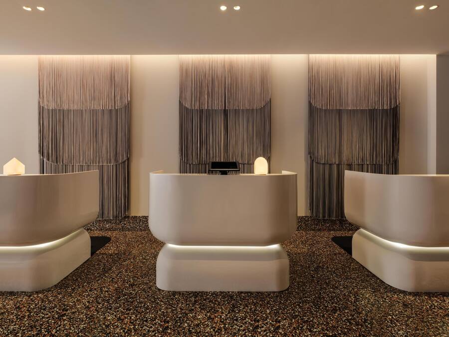 Um espaço de spa com três grandes banheiras curvas e brancas e um balcão de atendimento.