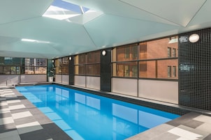 Una piscina techada, sillones reclinables de piscina