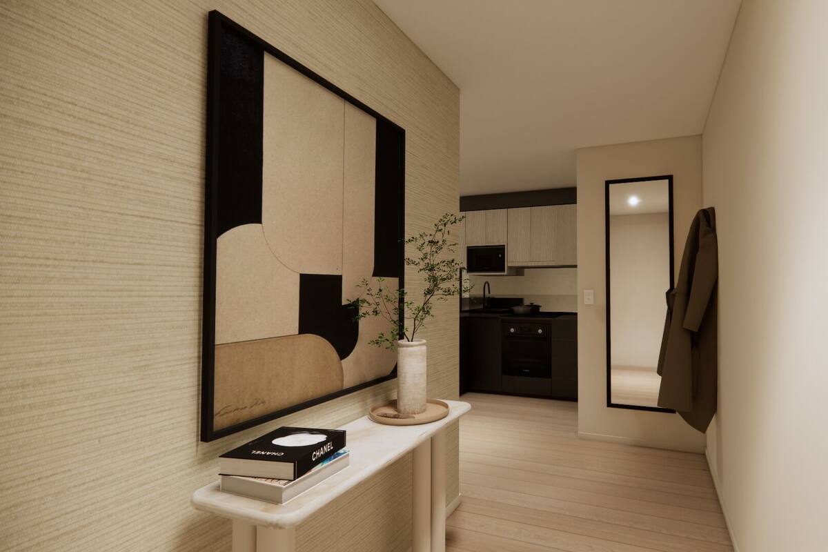 A hallway with a modern design, a mirror, a vase with a plant, and a book on a console table.