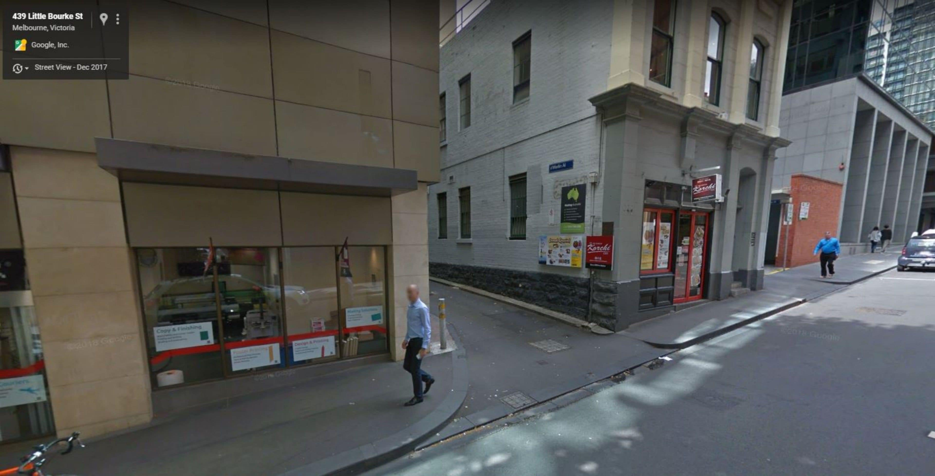 Et gadesyn med en bygning, der har store vinduer og et skilt med 'Google, Inc.'