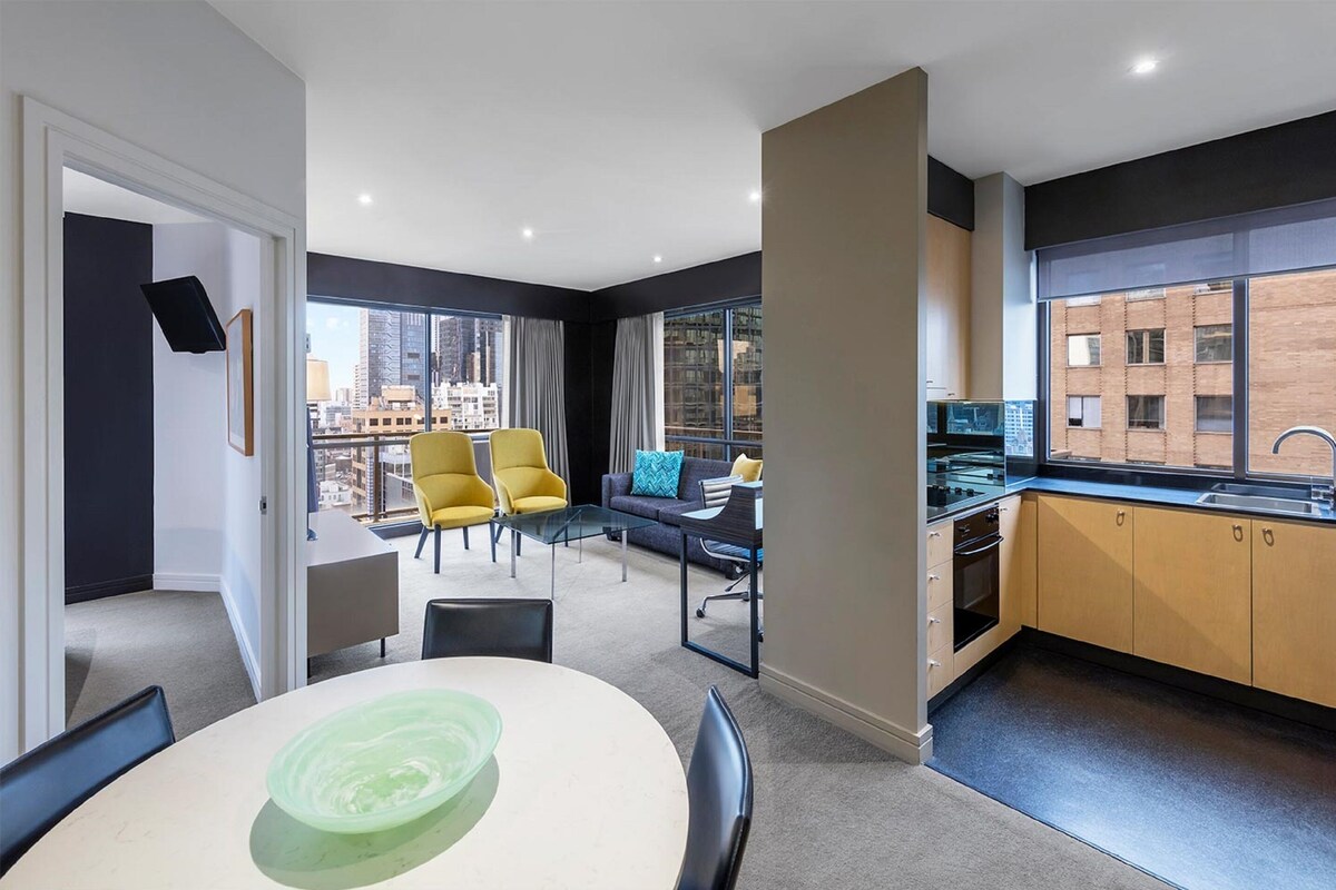 Een modern appartement met een eethoek, keuken en een balkon met uitzicht op de stad.