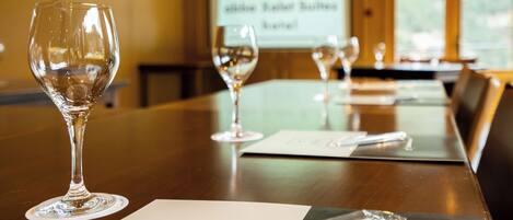A conference table with empty wine glasses and name cards.