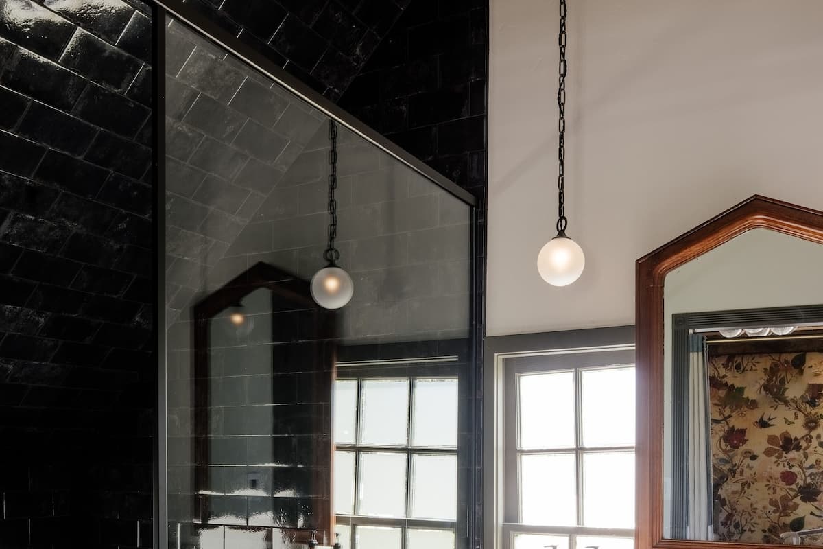 A modern bathroom with a freestanding bathtub, a large mirror, and a marble countertop.