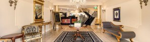 A grand lobby with a chandelier, a reception desk, a staircase, and classic furniture. - Canterbury International Hotel (Forest Hill)