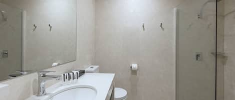 Ett modernt badrum med en stor tvättställ, en toalett och en dusch med glasväggar.