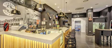 A modern bar area with a counter, stools, and a cityscape mural.