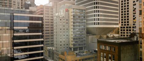 A cityscape with modern high-rise buildings, including a hotel with a distinctive cylindrical top.