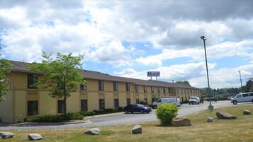 A Mobil-branded motel with multiple rooms, a parking lot, and a grassy area with rocks.