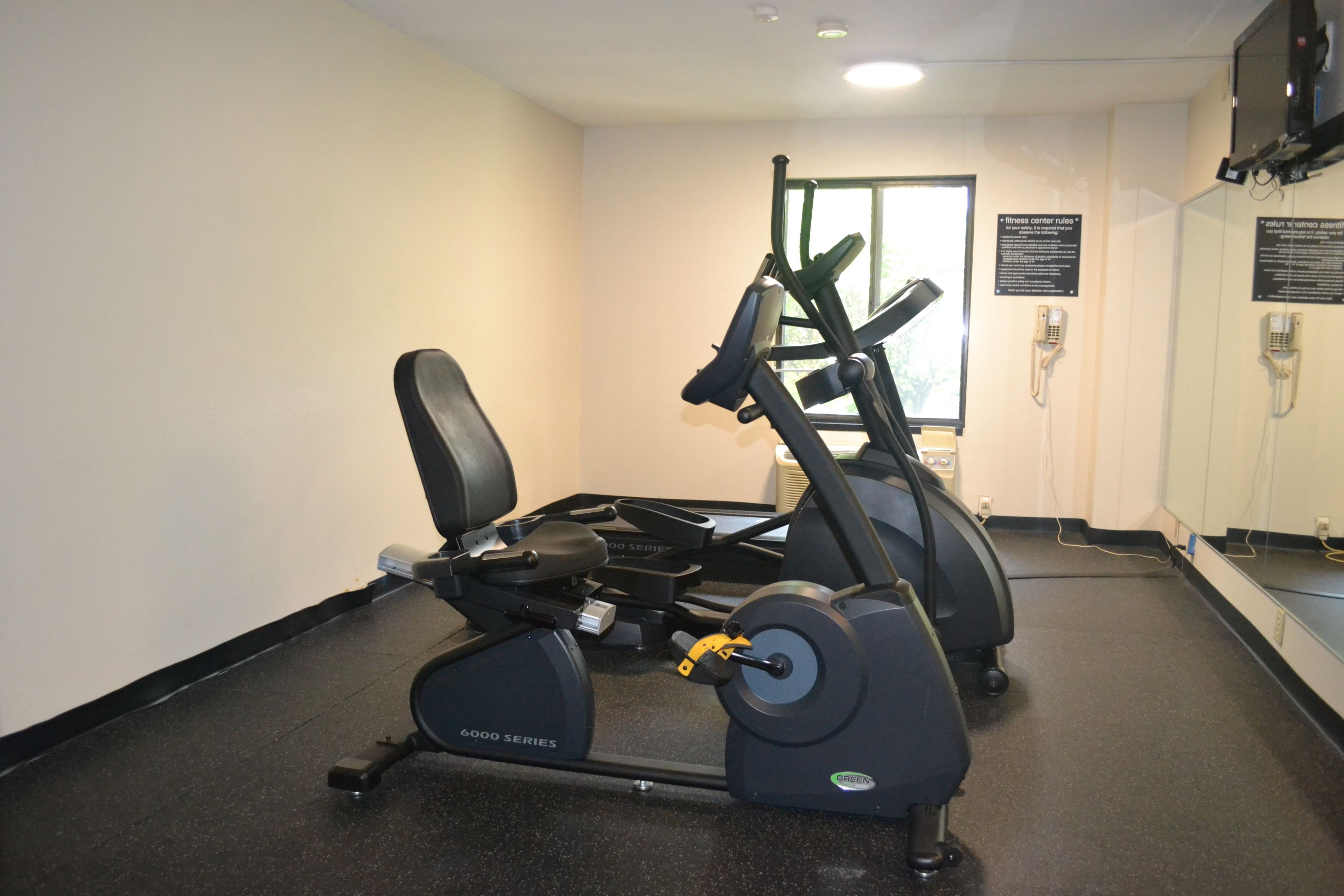 Un centre de remise en forme équipé de machines de cardio, d’un tapis de course et d’un vélo d’appartement.