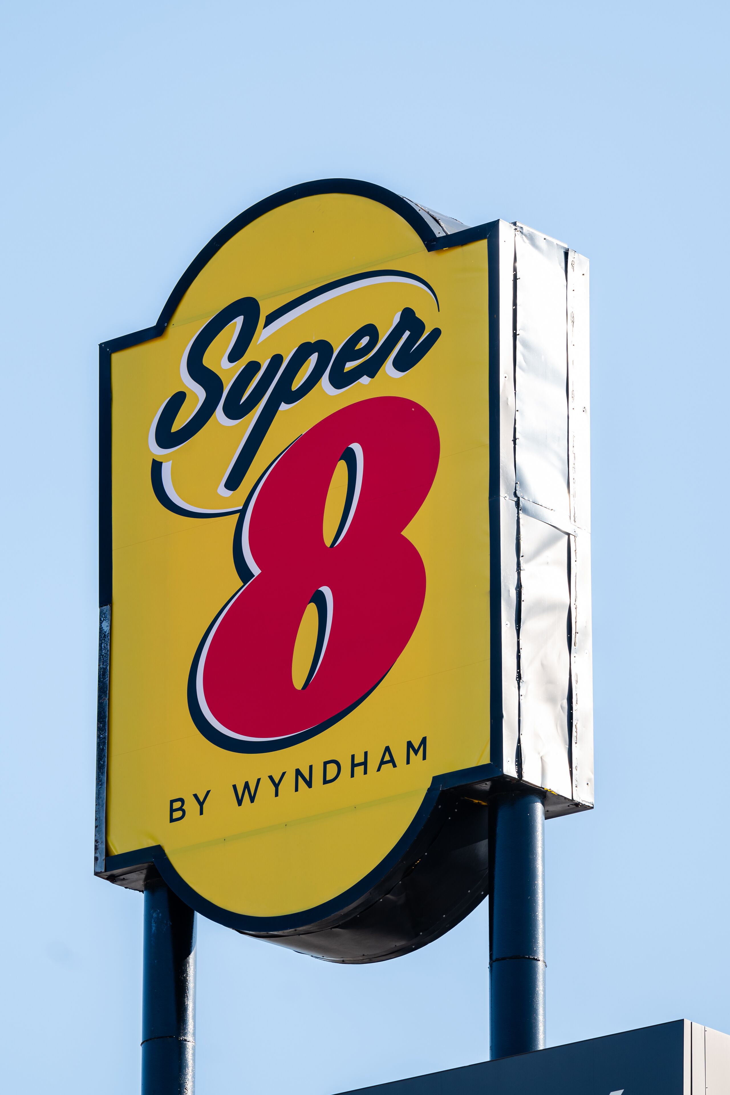 A yellow sign with "Super 8" and "By Wyndham" written on it.