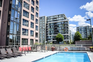 Una piscina al aire libre, tumbonas