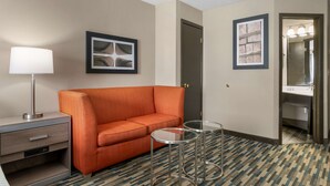 A hotel room with a sofa, a lamp, two small tables, and a framed picture on the wall. - Best Western Edinburgh/Columbus (Edinburgh)