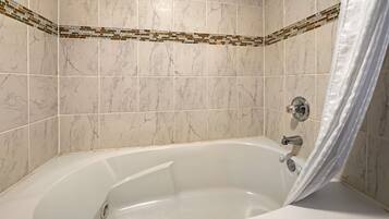 A bathroom with a freestanding bathtub, tiled walls, and a shower curtain.