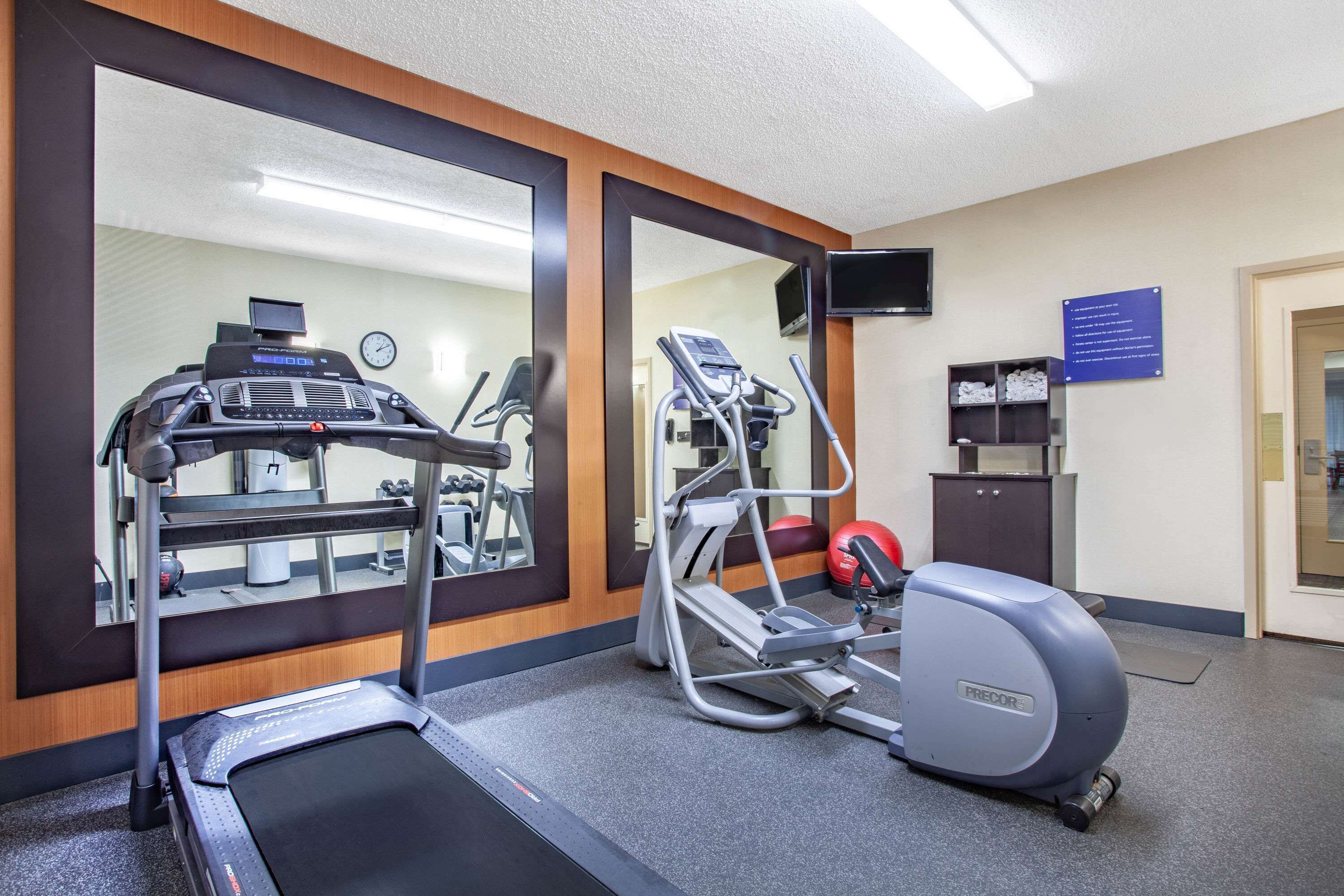 A gym with a treadmill, elliptical, and a stationary bike.