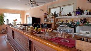 Uma cozinha com balcão de madeira, diversos alimentos e eletrodomésticos.