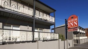 A Motor Inn building with a balcony, a sign indicating a vacancy, and a pool area. - Central City Motor Inn (Bakery Hill)