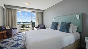 A hotel room with a large bed, a sofa, a chair, and a balcony with a view. - The Gladstone (Gladstone)