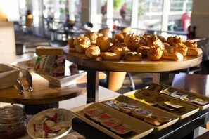 A buffet with various pastries and food items.