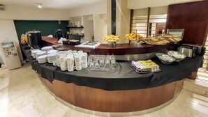 Un comptoir de buffet avec des assiettes, des tasses et divers aliments.