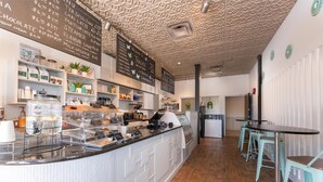 A modern cafe with a counter displaying various food items and a chalkboard menu. - Prestige Rocky Mountain Resort Cranbrook, WorldHotels Crafted (Cranbrook)