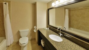 A bathroom with a toilet, sink, and mirror.