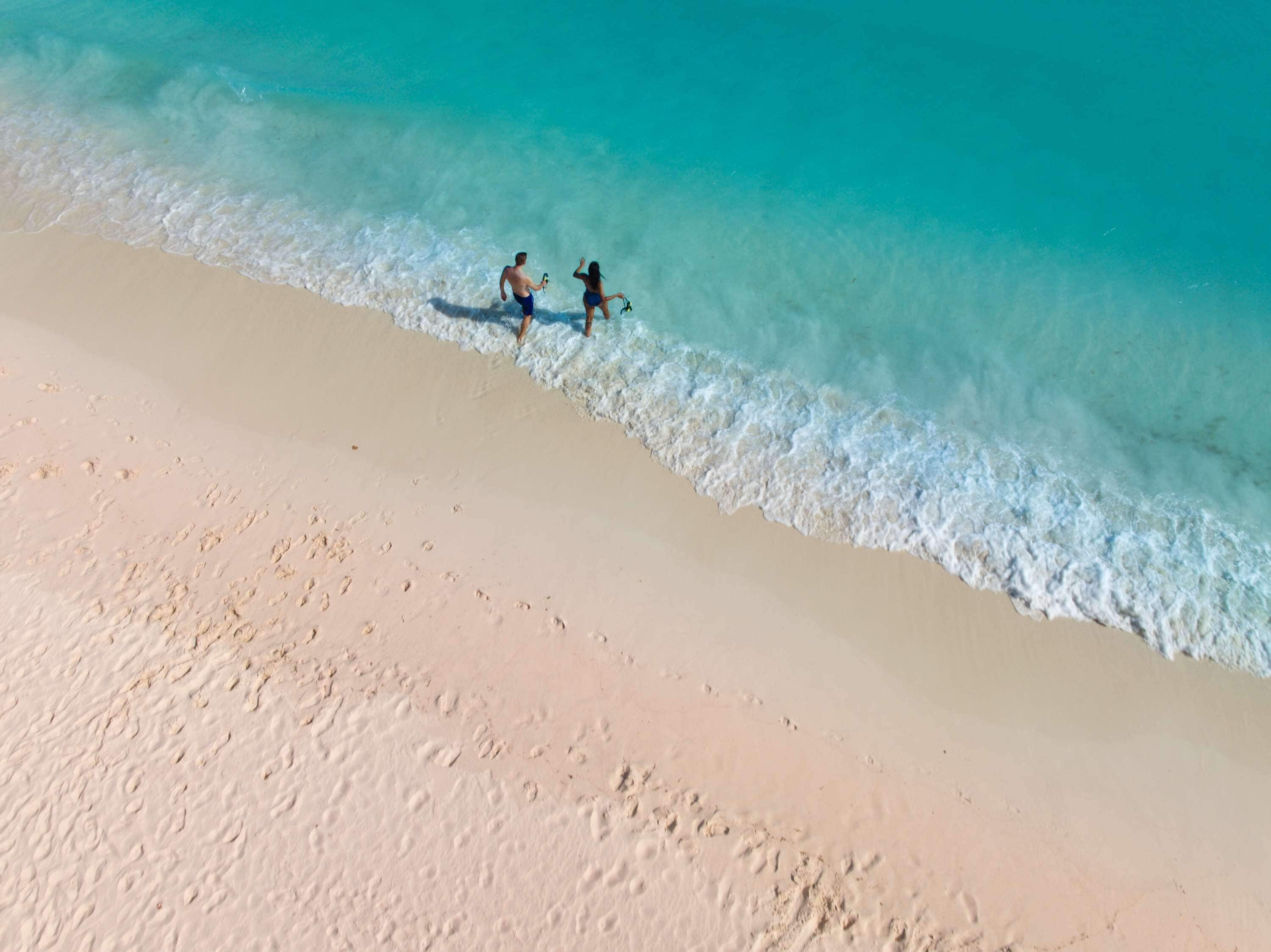 A beach with clear turquoise water and a sandy shore.