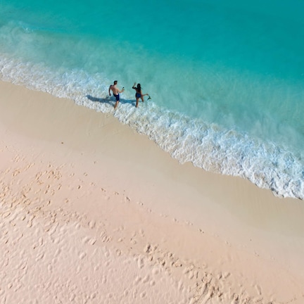 A beach with clear turquoise water and a sandy shore.