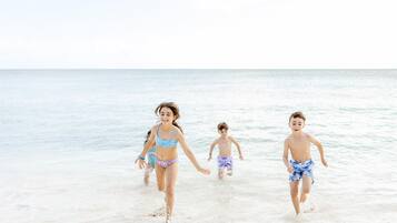 En la playa, arena blanca, sillas reclinables de playa, toallas de playa