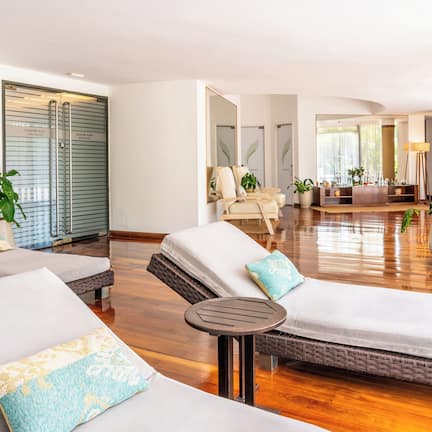 A spacious lounge area with multiple seating options, including a sofa and a chair, and a small table.