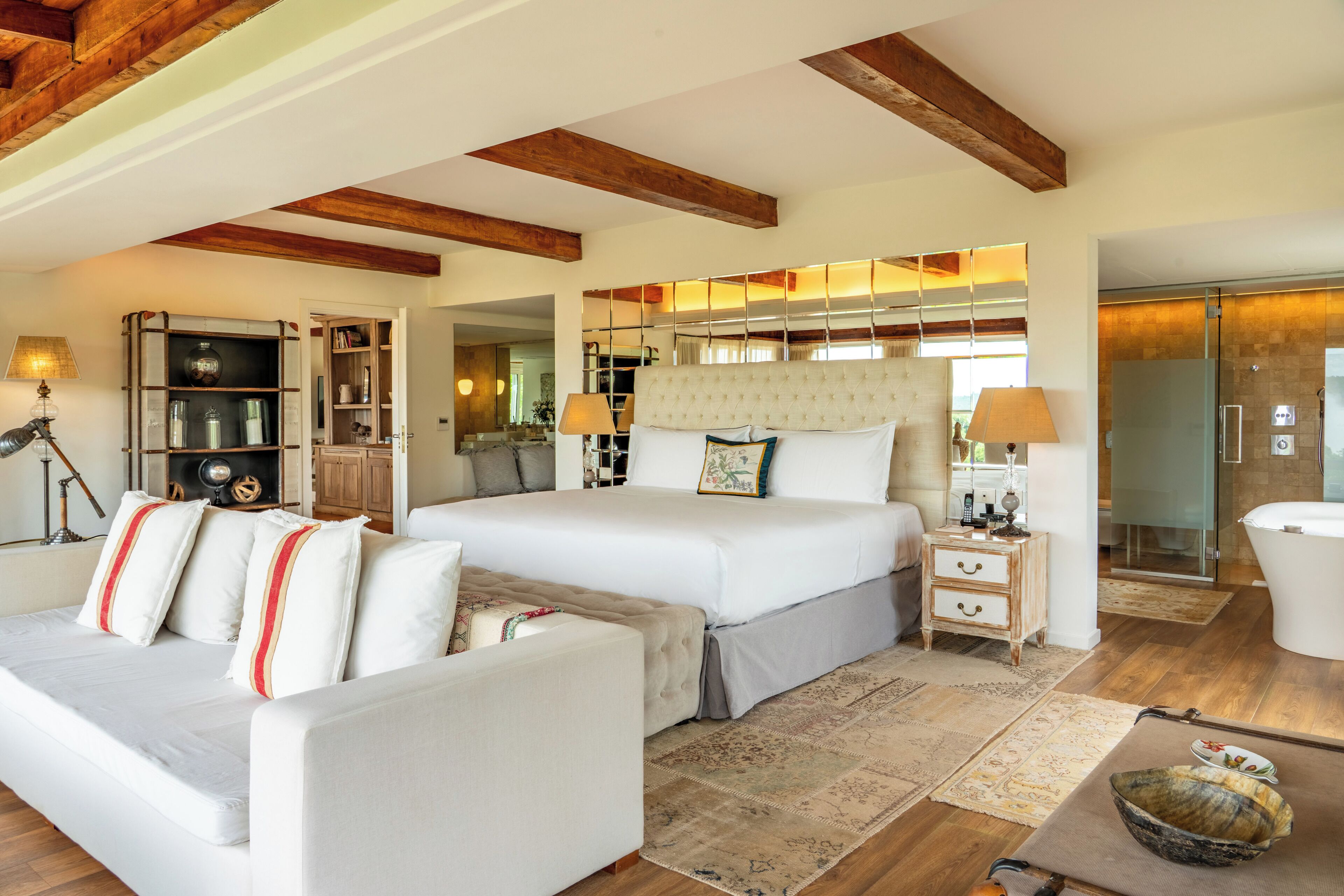 Une chambre à coucher avec un grand lit, un canapé, une table de chevet et une armoire.