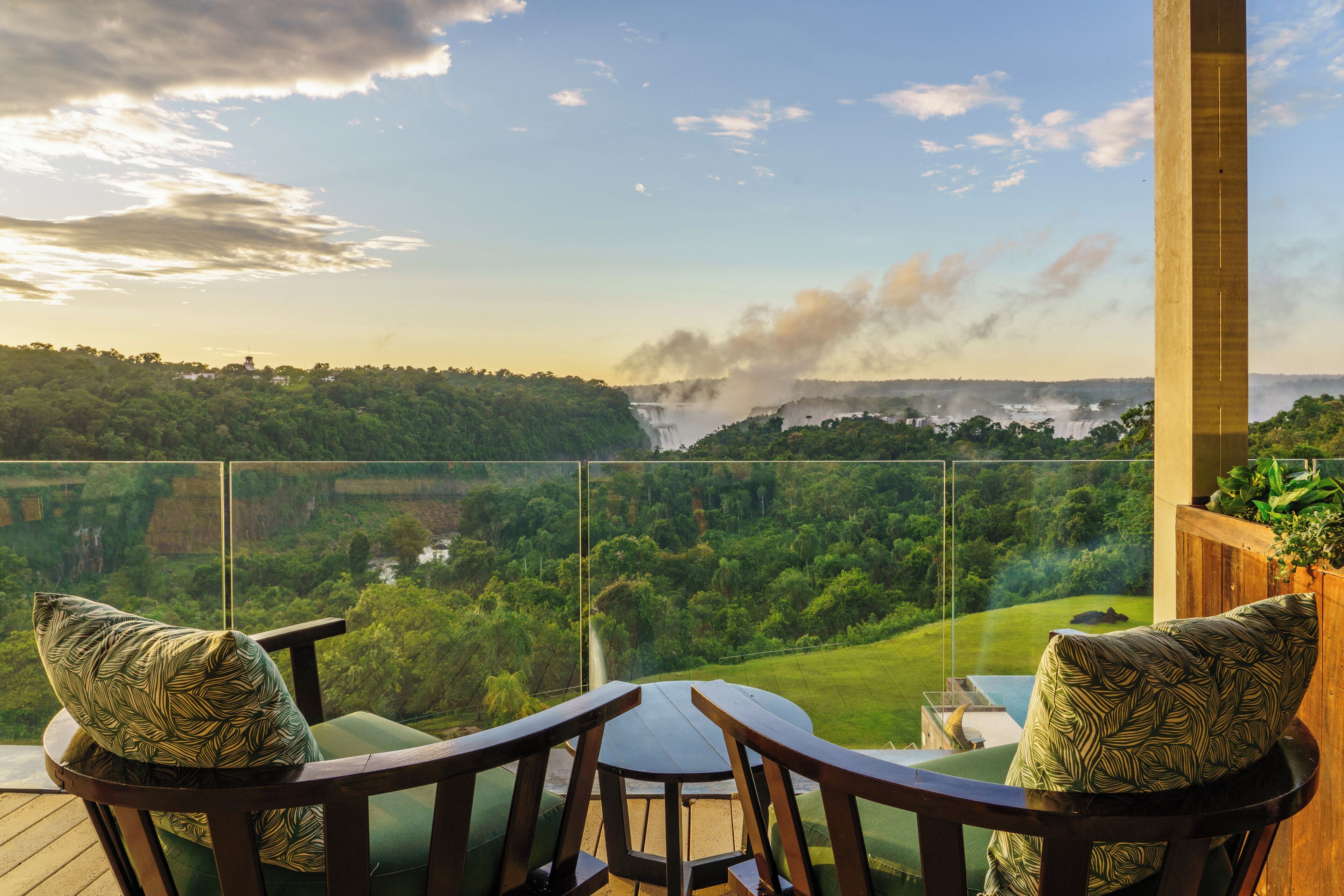 Un balcon offrant une vue sur une cascade et une végétation luxuriante.