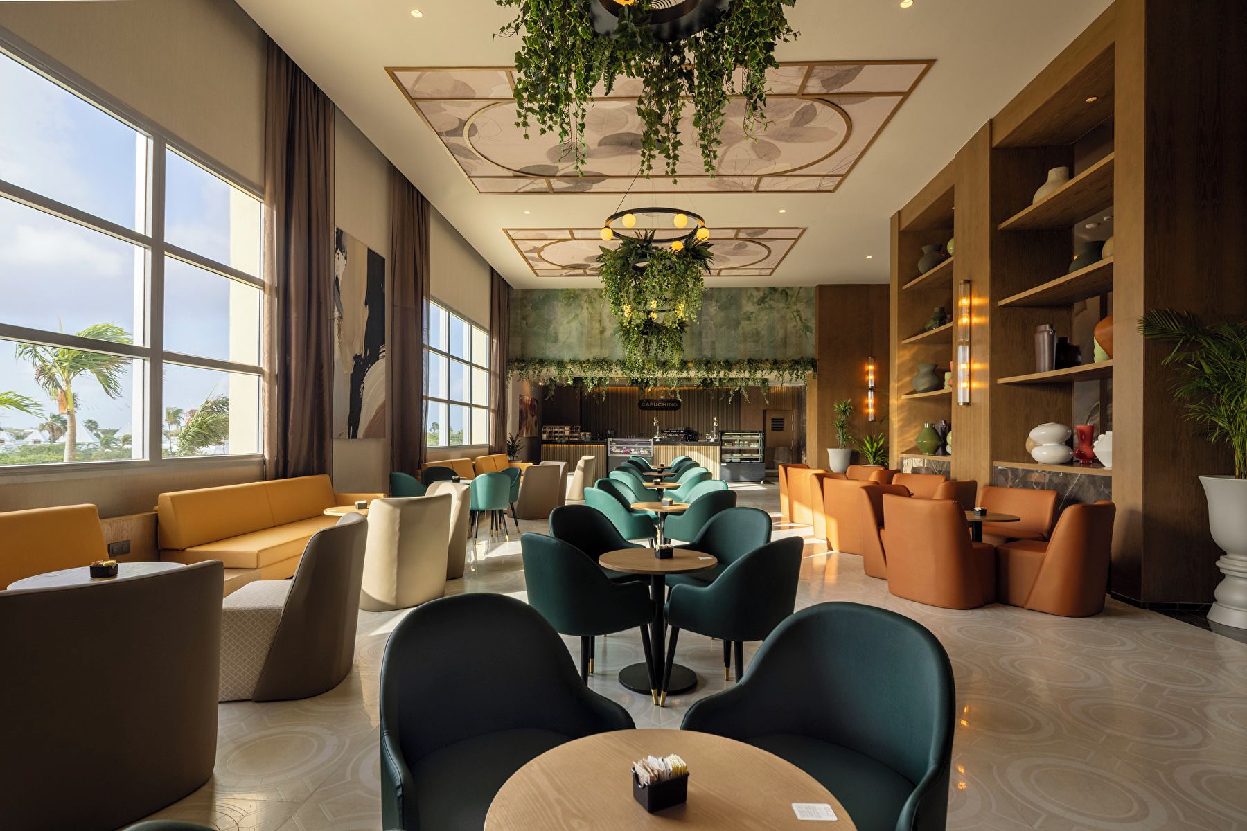 A modern lounge area with seating, a bar, and a view of palm trees.