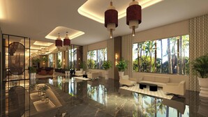 A modern lobby with a reflective floor, seating areas, and large windows with a view of palm trees. - Hotel Riu Palace Aruba - All Inclusive (Noord)