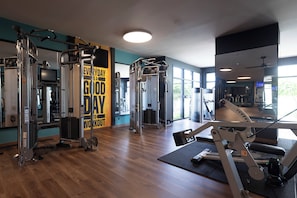 A gym with various exercise equipment, a motivational quote on the wall, and large windows allowing natural light. - Hotel Riu Palace Aruba - All Inclusive (Noord)