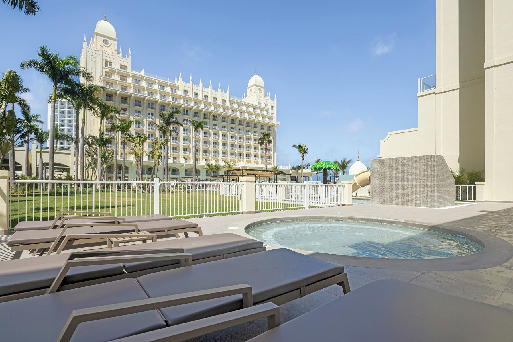 Un hôtel doté d’un grand bâtiment, d’une piscine et de chaises longues.