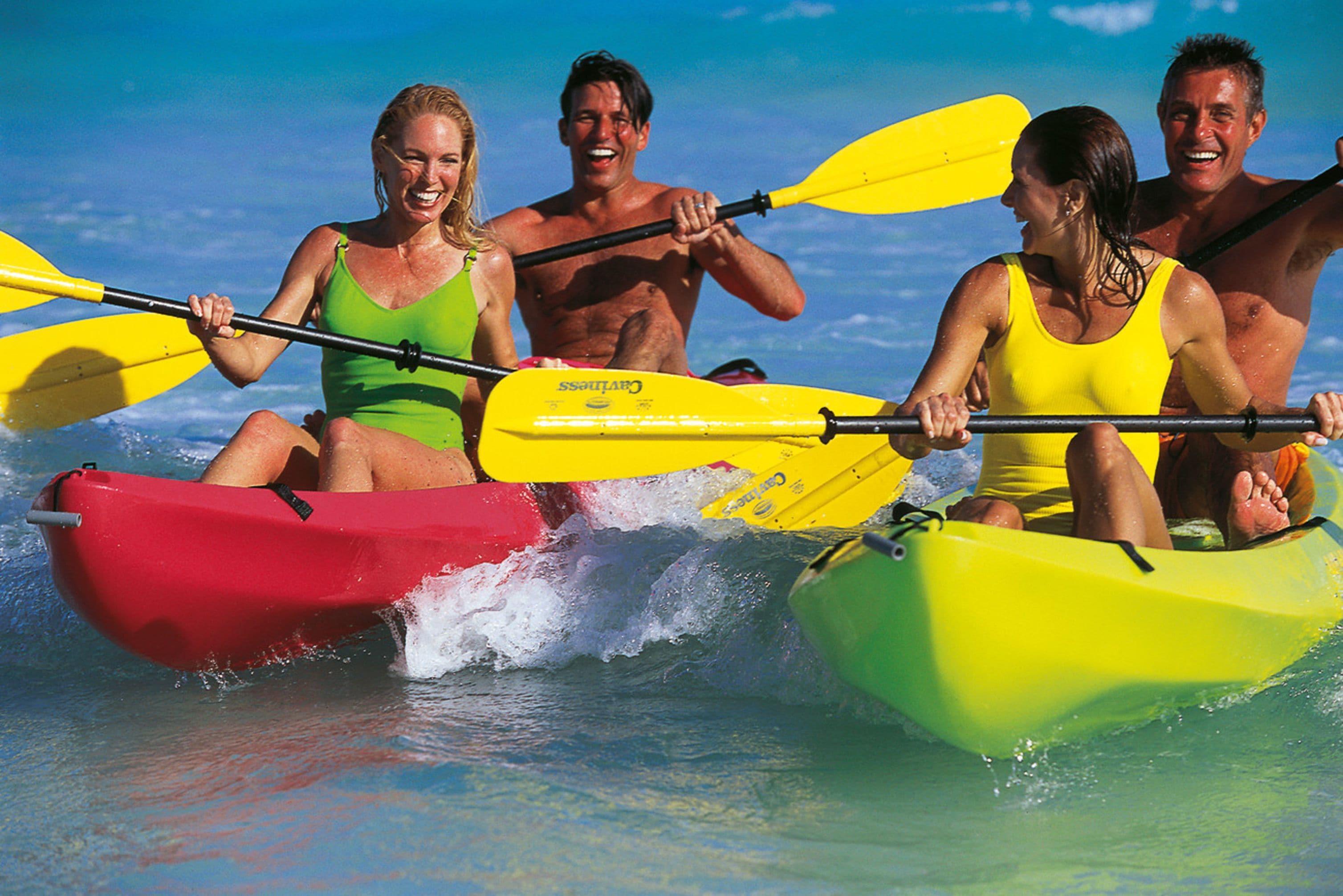 A group of people kayaking on a beach.