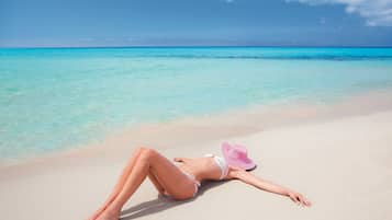 Sulla spiaggia, sabbia bianca, lettini da mare, ombrelloni