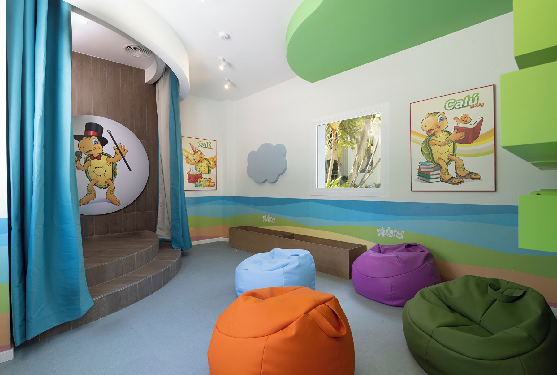 Un espace de jeux pour enfants avec des poufs colorés et des décorations murales.