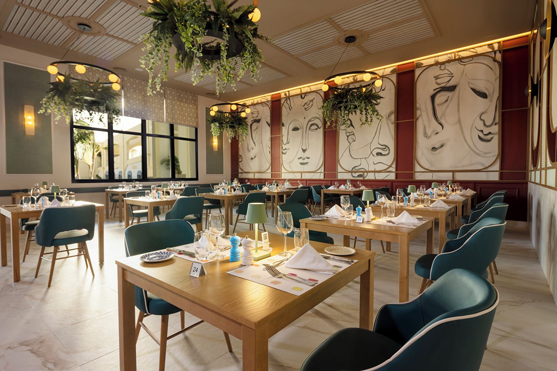 Un restaurante con varias mesas, sillas y plantas colgantes.
