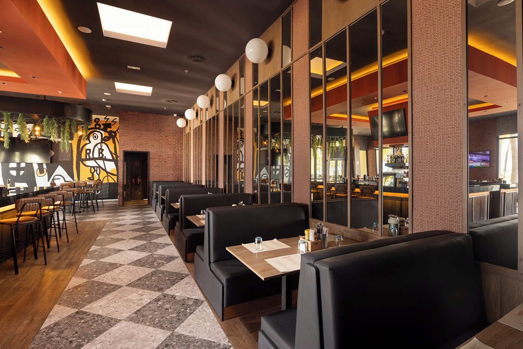 A restaurant interior with booths, tables, and a bar area.