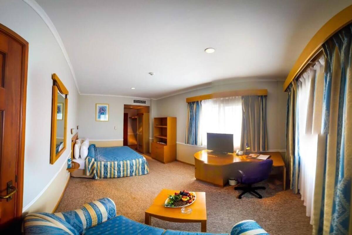 Une chambre d’hôtel équipée d’un lit, d’un bureau, d’un canapé et d’une télévision.