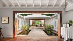 A wooden pathway leading to a dining area with potted plants on either side. - Pink Sands Resort (Dunmore Town)