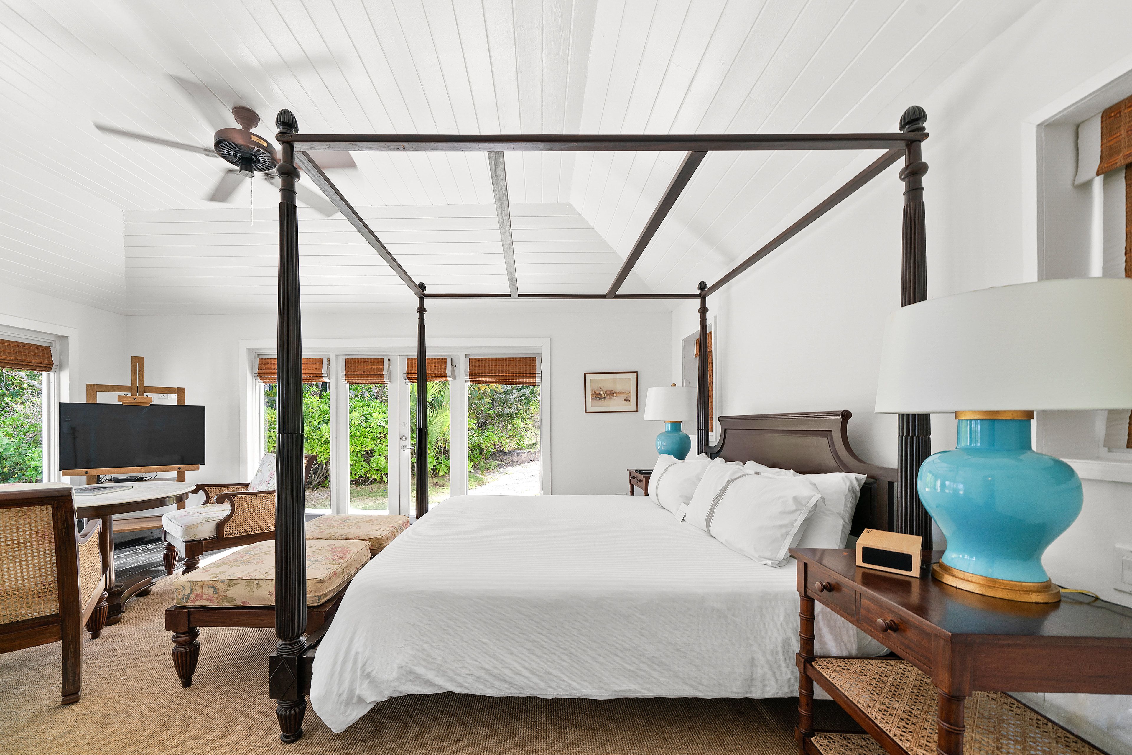 A four-poster bed with a television and desk in the room.
