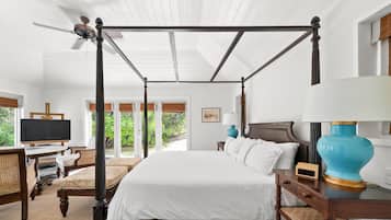 A four-poster bed with a television and desk in the room.